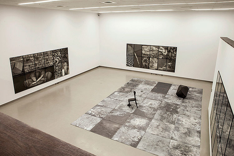 Ausstellung grosser Raum von oben mit zwei Bildern und einer Bodeninstallation mit Sessel